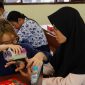 Salah satu anggota tim inovator ITS, Firania Putri Harsanti, mempraktikkan cara menggunakan Neutrack AI Glove pada salah satu siswa SMPLB-A YPAB Surabaya. Foto: ITS