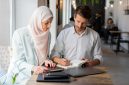 Dua profesional sedang bekerja bersama dengan penuh fokus, mencerminkan etos kerja yang terencana, terstruktur, dan produktif sebagaimana diajarkan dalam Islam. Foto: Pexels/Mikhail Nilov