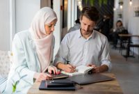 Dua profesional sedang bekerja bersama dengan penuh fokus, mencerminkan etos kerja yang terencana, terstruktur, dan produktif sebagaimana diajarkan dalam Islam. Foto: Pexels/Mikhail Nilov