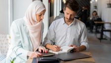 Dua profesional sedang bekerja bersama dengan penuh fokus, mencerminkan etos kerja yang terencana, terstruktur, dan produktif sebagaimana diajarkan dalam Islam. Foto: Pexels/Mikhail Nilov