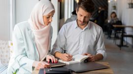 Dua profesional sedang bekerja bersama dengan penuh fokus, mencerminkan etos kerja yang terencana, terstruktur, dan produktif sebagaimana diajarkan dalam Islam. Foto: Pexels/Mikhail Nilov