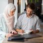 Dua profesional sedang bekerja bersama dengan penuh fokus, mencerminkan etos kerja yang terencana, terstruktur, dan produktif sebagaimana diajarkan dalam Islam. Foto: Pexels/Mikhail Nilov