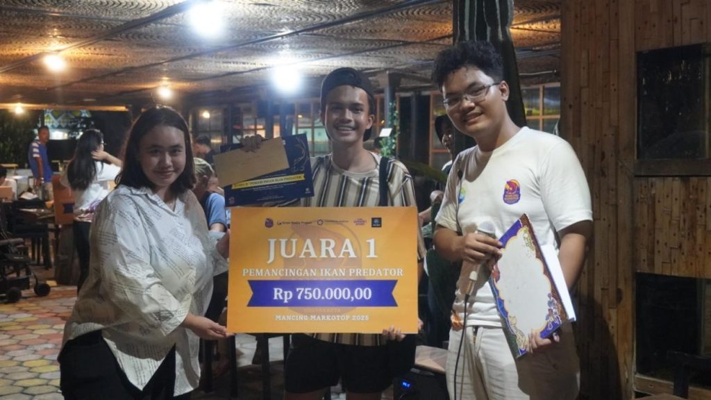 Penyerahan hadiah untuk salah satu pemenang lomba mancing ikan predator Mancing Markotop 2025 oleh Dosen Universitas Amikom Yogyakarta, Ibu Rufki Ade Vinanda, S.I.Kom., M.A. dan Ketua panitia Mancing Markotop 2025, Akhmad Basila Rahman. Foto: pribadi