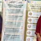 Mahasiswa KKN bersama perangkat Desa Kadirejo memperkenalkan infografis syarat pembuatan akta kelahiran dan kematian yang dipasang di kantor desa. Foto: pribadi