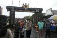 Petugas keamanan bersama Panitia berjaga di gerbang Rowokangkung untuk memastikan karnaval PAUD dalam rangka HUT RI ke-80 berlangsung aman dan tertib. Foto: ist
