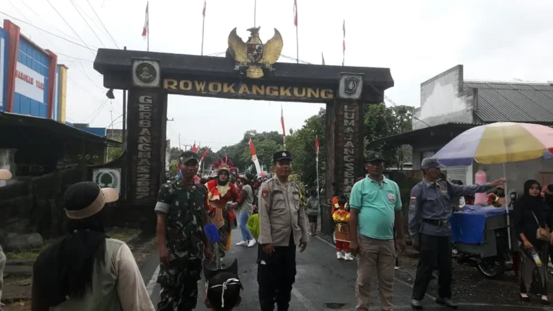 Petugas keamanan bersama Panitia berjaga di gerbang Rowokangkung untuk memastikan karnaval PAUD dalam rangka HUT RI ke-80 berlangsung aman dan tertib. Foto: ist