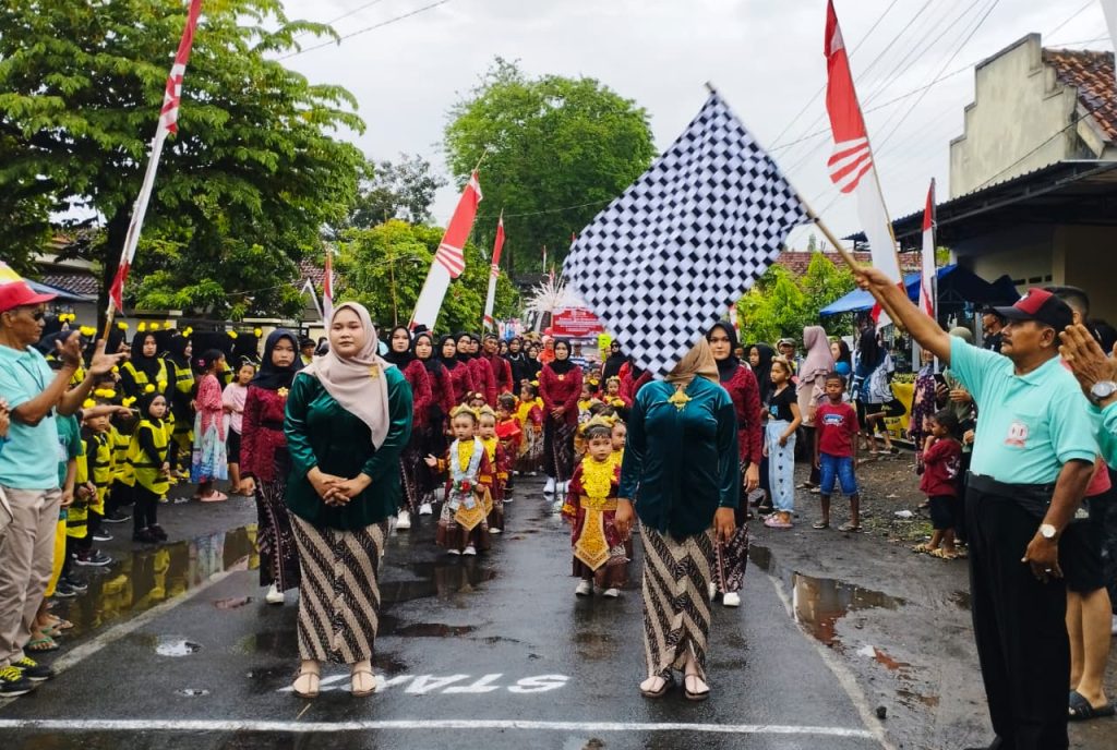 Sugito, Ketua Panitia HUT RI ke 80 Desa Rowokangkung saat memberangkatkan peserta karnaval PAUD. Foto: ist