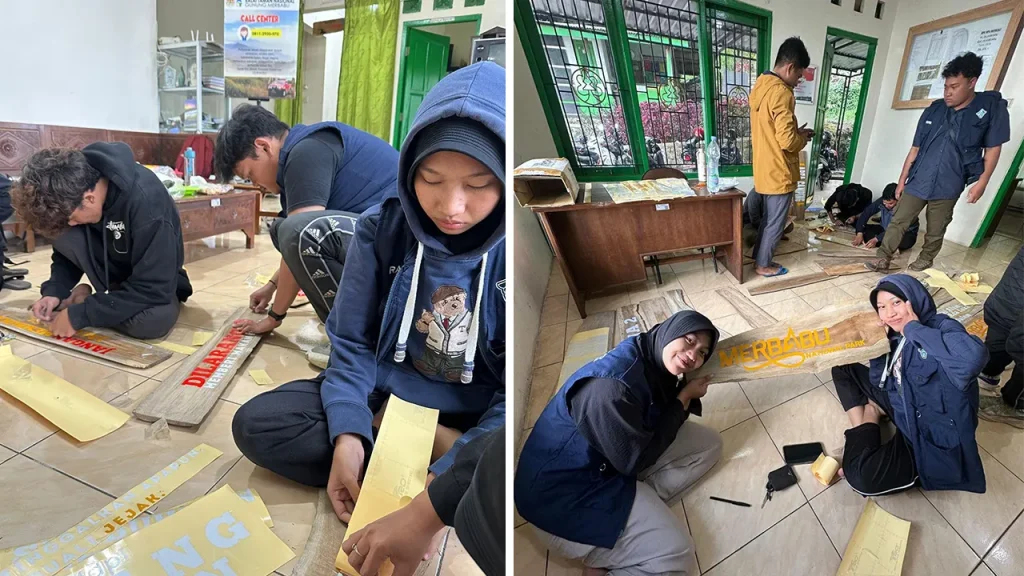 Mahasiswa KKN 32 UNS membantu memasang stiker informasi papan jalur pendakian Gunung Merbabu sebelum dipasang. Foto: KKN 32 UNS