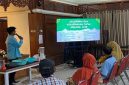 Salah satu mahasiswa KKN UNS 131 memberikan penjelasan kepada warga Kelurahan Kepatihan Wetan, Jebres, Surakarta, mengenai kelebihan dan kekurangan pupuk organik cair berbahan limbah makanan dalam pelatihan pengolahan kompos cair, Jumat (29/8/2025). Foto: KKN 131 UNS