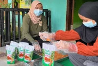 Mahasiswa KKN-T Unram bersama pengrajin Giri Madia menimbang dan mengemas gula semut hasil produksi lokal sebagai bagian dari pelatihan peningkatan mutu dan pemasaran produk aren. Foto: Tim KKN Tematik Desa Giri Madia