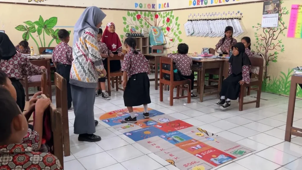 Permainan tradisional engklek yang dimodifikasi dengan tantangan edukatif tentang konsep energi. Setiap kotak berisi soal atau misi sederhana terkait sumber energi, perubahan energi, dan contoh pemanfaatannya di kehidupan sehari-hari. Foto: Tim GAMINAYU UNS
