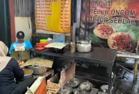 Seorang penjual surabi di Cibiru, Bandung tampak sedang menyiapkan pesanan pelanggan, Rabu (3/12/2025). Foto: Dokumen Pribadi/Sinthia Rahmawati