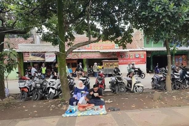 Tampak sekelompok pengunjung sedang menikmati bakso ‘ngampar’ tepi sungai. Foto: Pribadi/Aulia Syifa Salsabila