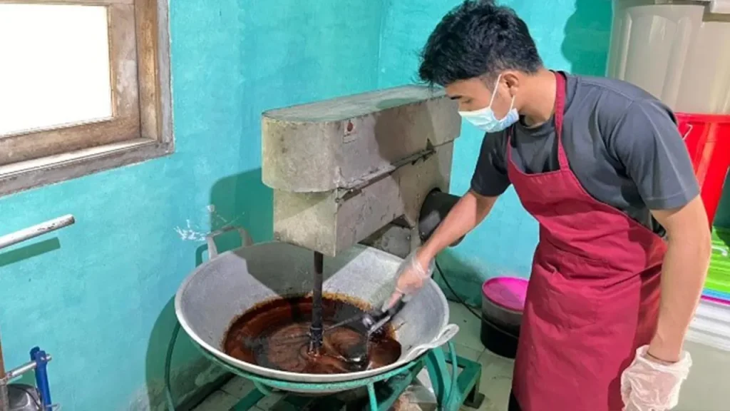 Uji teknis mengaduk larutan nira aren saat proses pembuatan gula semut menggunakan peralatan produksi di Desa Giri Madia, Lombok Barat. Foto: Tim KKN Tematik Desa Giri Madia