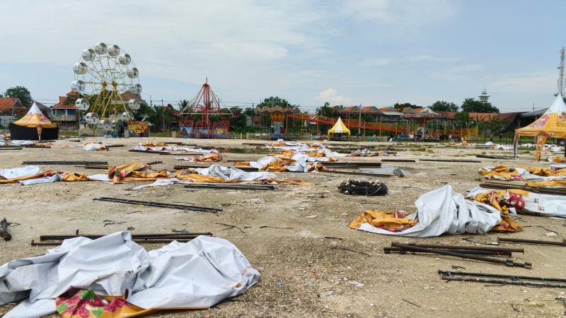 Kondisi Lapangan Gajah Mada, Lamongan, Minggu (20/12/2025), dipenuhi rangka besi dan terpal stan pasar malam yang roboh usai diterjang hujan deras disertai angin kencang. Foto: Pribadi