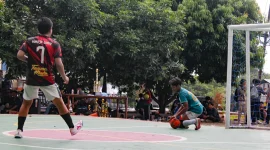 Ilustrasi seorang pemain futsal berusaha mengamankan bola di depan gawang saat laga berlangsung. Aktivitas dengan intensitas tinggi seperti ini menuntut kesiapan fisik, stabilitas tubuh, dan pemulihan yang tepat agar atlet terhindar dari cedera dan tetap tampil optimal di lapangan. Foto: Pibadi