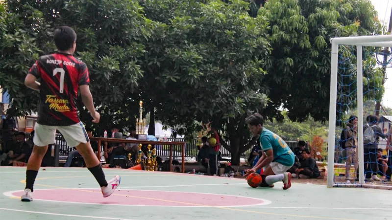 Ilustrasi seorang pemain futsal berusaha mengamankan bola di depan gawang saat laga berlangsung. Aktivitas dengan intensitas tinggi seperti ini menuntut kesiapan fisik, stabilitas tubuh, dan pemulihan yang tepat agar atlet terhindar dari cedera dan tetap tampil optimal di lapangan. Foto: Pibadi