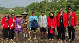 Mahasiswa Universitas 17 Agustus 1945 (UNTAG) Surabaya berfoto bersama petani di lahan pertanian Desa Kuripansari usai kegiatan pendampingan pemanfaatan alat penebar pupuk jagung, sebagai bagian dari program pengabdian masyarakat untuk meningkatkan efisiensi pemupukan dan produktivitas hasil panen. Foto: Pribadi