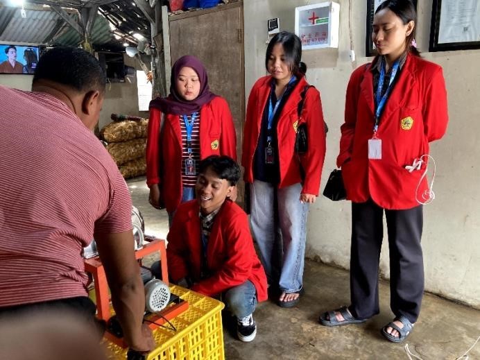 Mahasiswa KKN Universitas 17 Agustus 1945 (UNTAG) Surabaya mendampingi pelaku UMKM Kurnia saat uji coba pengoperasian mesin slicer pisang di Desa Bendungan Jati, Kecamatan Pacet, Kabupaten Mojokerto, sebagai bagian dari upaya peningkatan efisiensi proses produksi olahan pisang. Foto: Pribadi