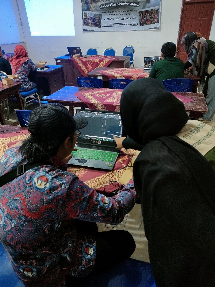 Tim KKN membantu salah seorang peserta saat sesi praktik. Foto: Tim KKN-T 151 UNS