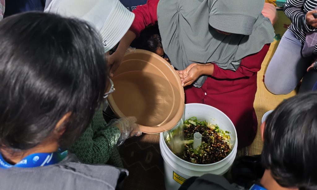 Peserta pelatihan mempraktikkan pembuatan pupuk organik cair didampingi mahasiswa KKN UNS. (Foto: KKN UNS 81 Seloprojo)