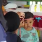 Seorang balita menjalani pengukuran lingkar kepala oleh petugas saat kegiatan posyandu di Desa Geneng, Ngawi. Pemeriksaan ini menjadi bagian dari upaya deteksi dini stunting dan pemantauan tumbuh kembang anak. Foto: Dokumentasi pribadi Kelompok 97 KKN UNS