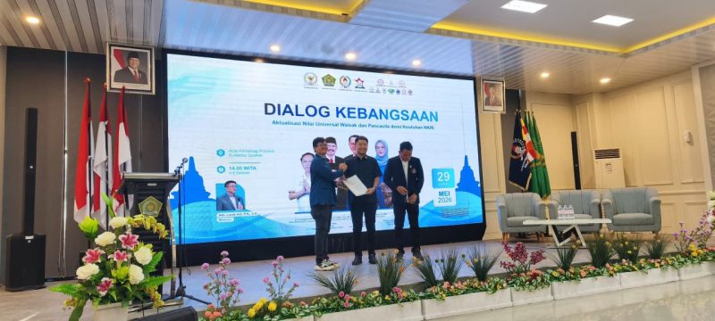 Prosesi penyerahan penghargaan dan pengangkatan Dewan Kehormatan DPD GEMABUDHI Sulawesi Selatan dalam rangkaian Dialog Kebangsaan bertema “Aktualisasi Nilai Universal Waisak dan Pancasila demi Keutuhan NKRI” di Aula Kantor Kementerian Agama Provinsi Sulawesi Selatan, Jumat (29/5/2026). Foto: Pribadi