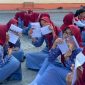 Siswa SMP Negeri 1 Muntilan dengan semangat menunjukan bahan bacaan di tengah pelaksanaan program literasi pagi yang digagas oleh mahasiswa Magang Kependidikan Terintegrasi (MKT) Universitas Tidar (UNTIDAR). (Dok. Pribadi/Magang Kependidikan Terintegrasi Universitas Tidar di SMP Negeri 1 Muntilan)